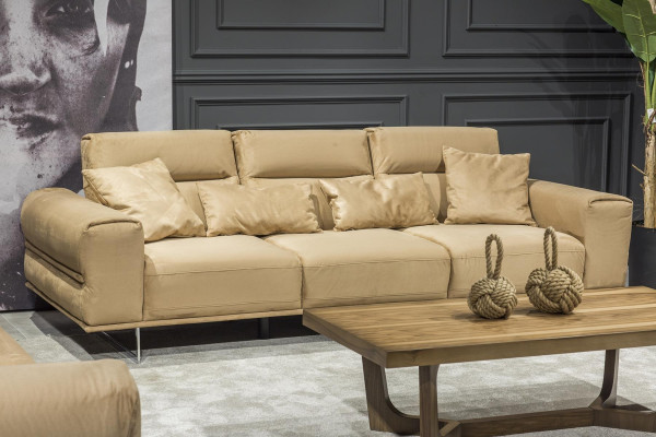 Beige verhoiltu kolmen hengen sohva, jossa tyynyt